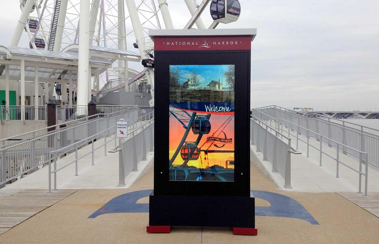 a large screen advertising a ferris wheel and a ferris wheel